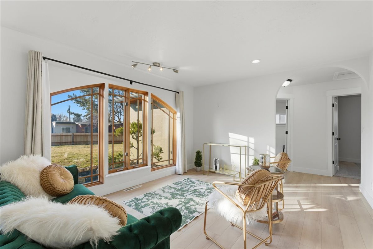 Living room featuring arched walkways, wood finished floors, and recessed lighting