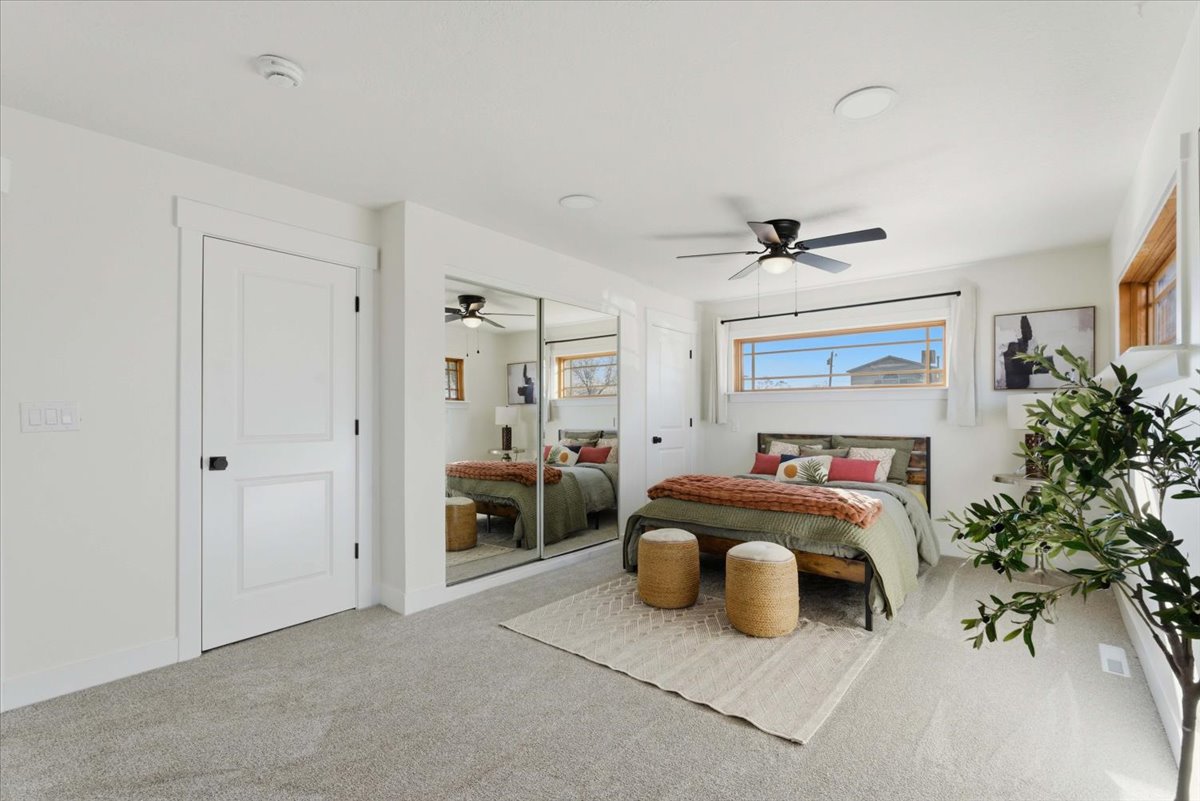 Carpeted bedroom featuring ceiling fan and a closet