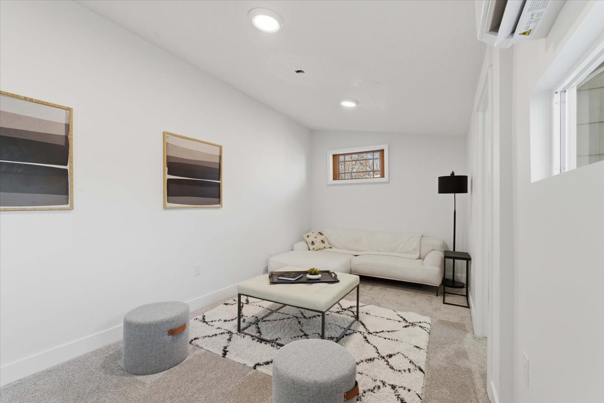 Living area with light carpet, recessed lighting, a wall mounted AC, and vaulted ceiling