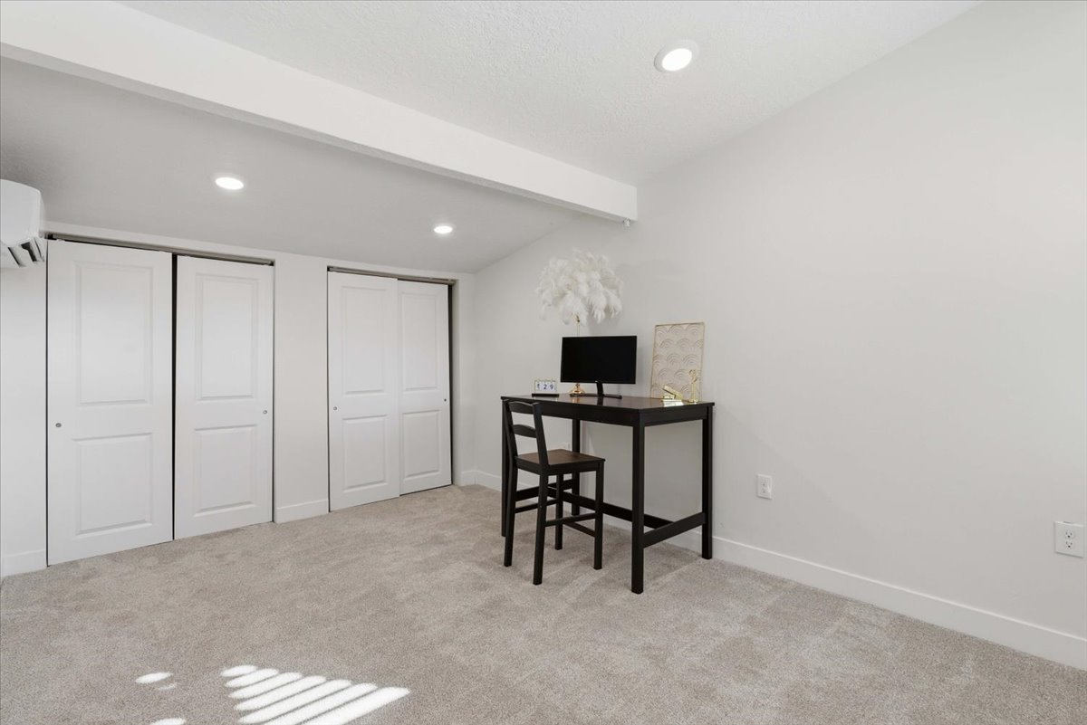Office area featuring beamed ceiling, light colored carpet, recessed lighting, and an AC wall unit