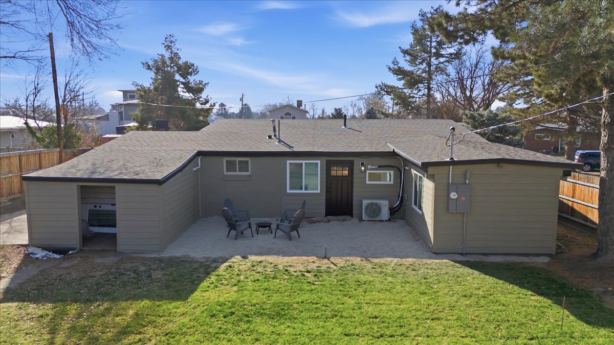 Rear view of house with a fenced backyard, a patio, and a shingled roof