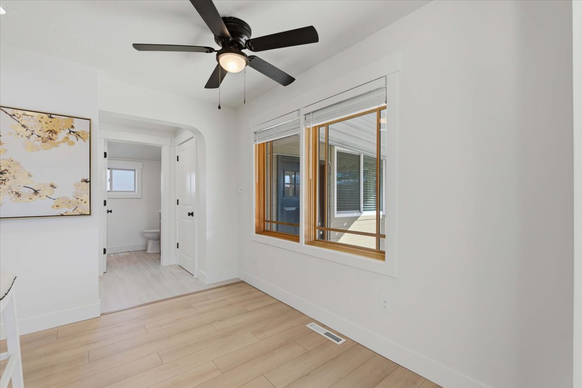 Empty room featuring light wood finished floors and a ceiling fan