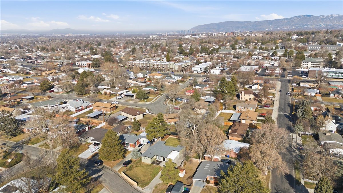 Aerial overview of property's location featuring a mountainous background and nearby suburban area