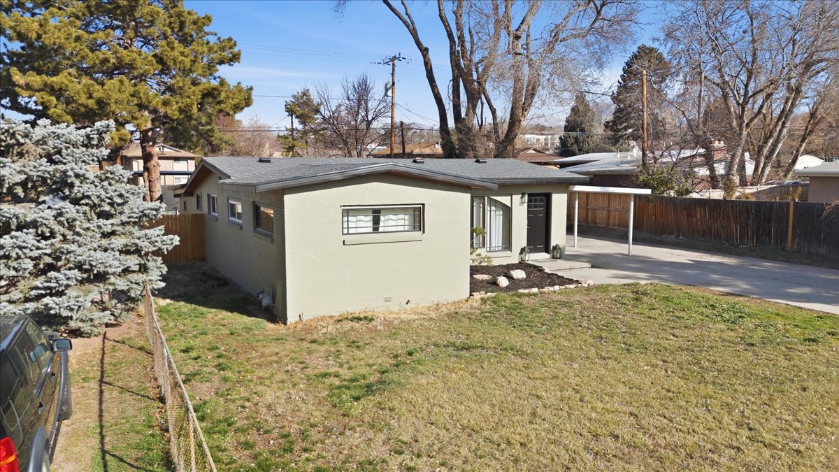 View of property exterior featuring stucco siding and driveway
