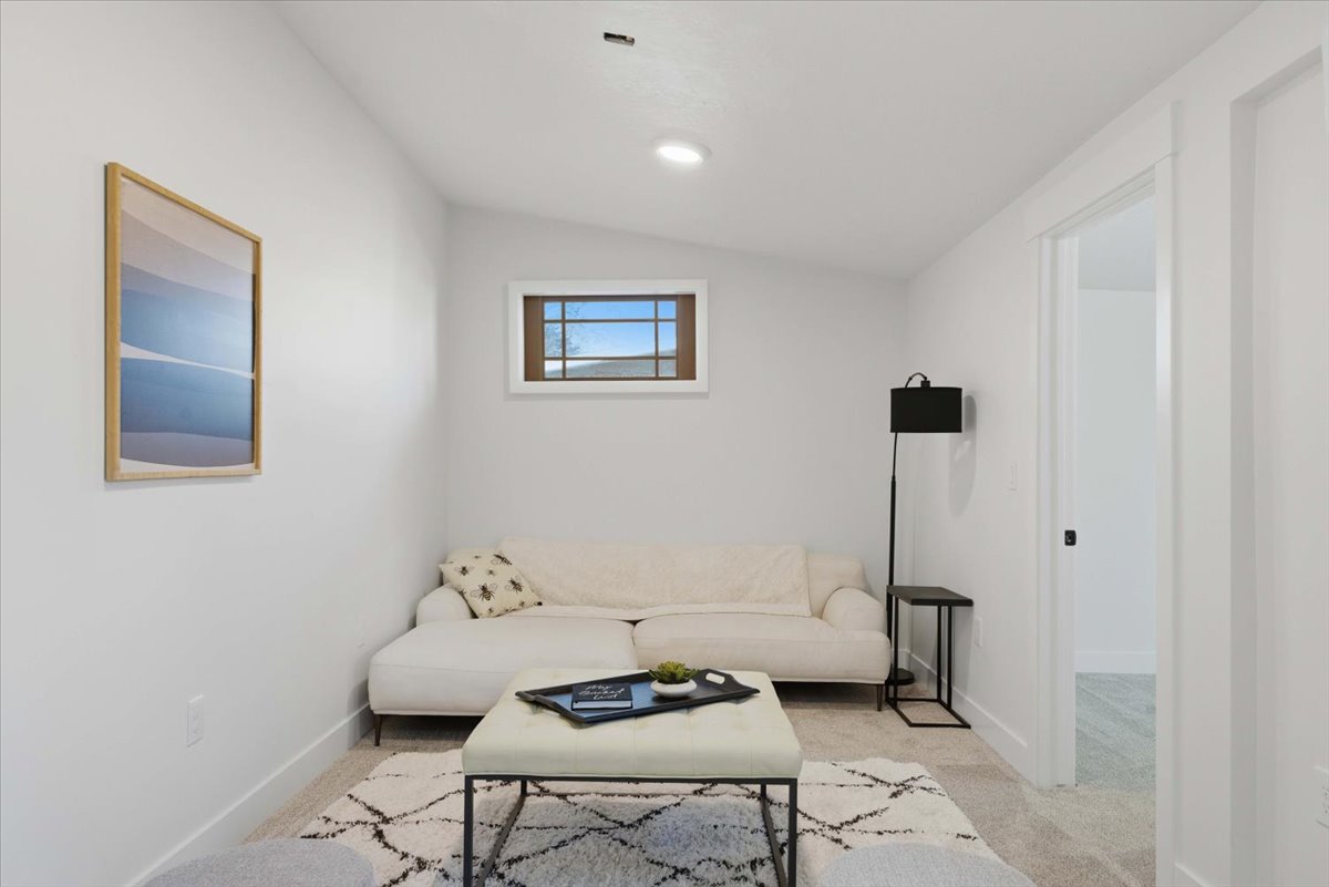 Living area with carpet and lofted ceiling