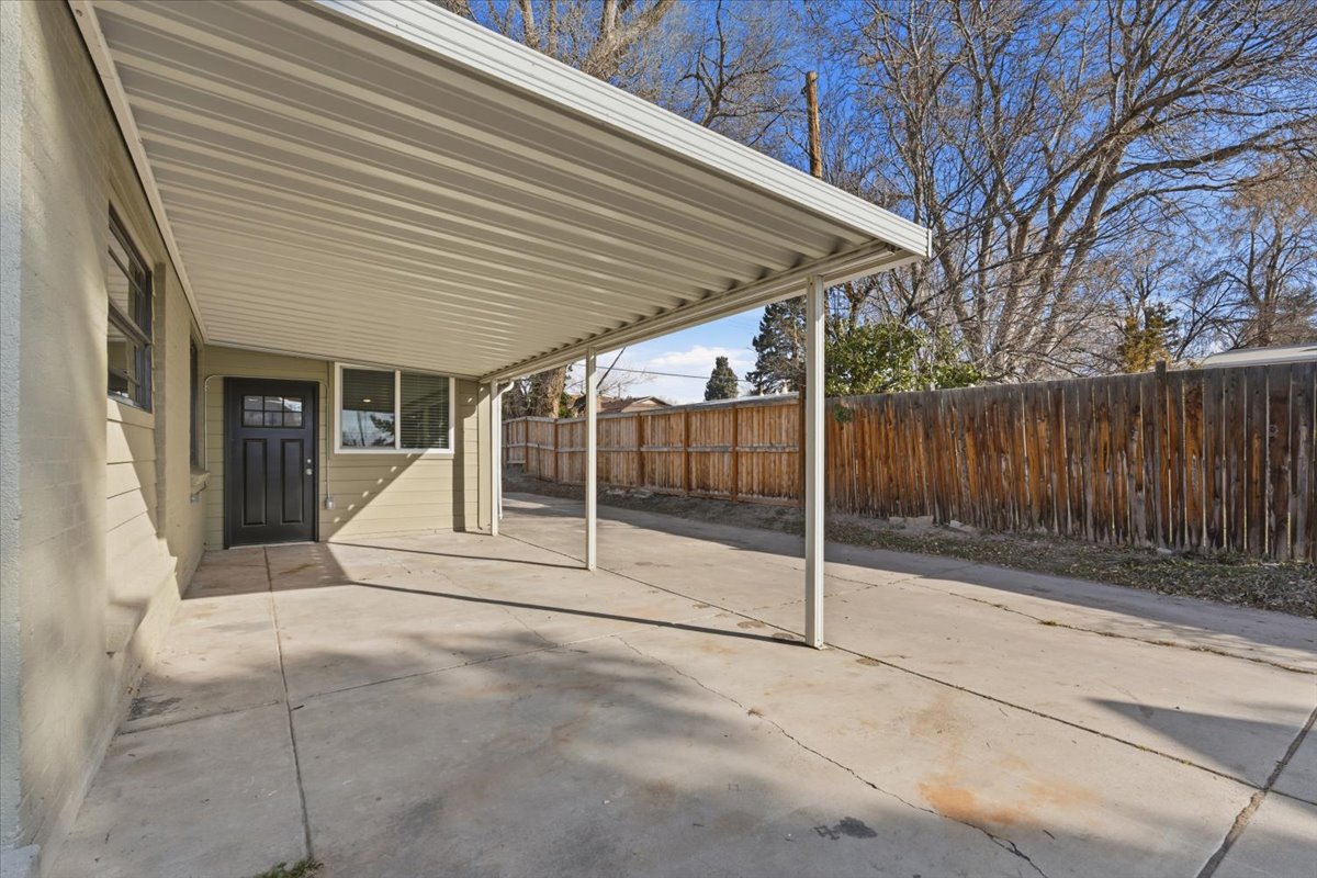 Fenced backyard with a patio area and an attached carport