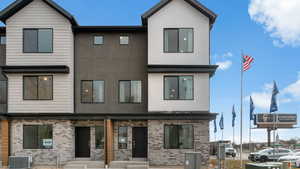 Modern home with brick siding, stucco siding, and covered porch