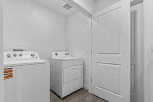 Laundry area with light wood-style floors and washing machine and dryer
