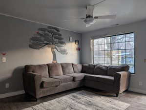 Living room featuring ceiling fan and wood finished floors