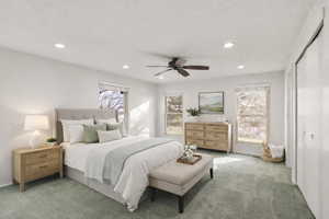 Carpeted bedroom with multiple windows, a ceiling fan, recessed lighting, and a closet