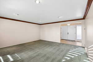 Unfurnished room featuring ornamental molding and light colored carpet