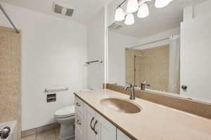 Bathroom featuring vanity, light tile patterned floors, and shower / tub combo with curtain