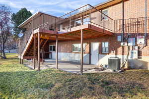 Back of property with a patio, a lawn, a deck, and stairway