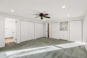 Unfurnished bedroom with multiple closets, carpet flooring, ceiling fan, and recessed lighting