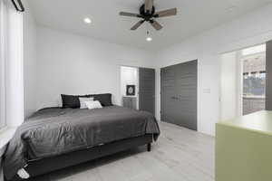 Bedroom with connected bathroom, recessed lighting, light wood-style floors, and a ceiling fan