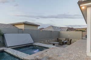 View of pool with a fenced backyard, a patio area, and an in-ground hot tub