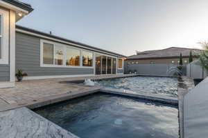 View of pool featuring a patio and a pool with connected hot tub