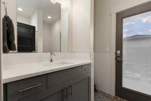 Bathroom with vanity, tile walls, and a wainscoted wall