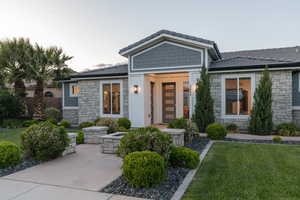 View of front of property featuring stone siding, a front lawn, and a tile roof