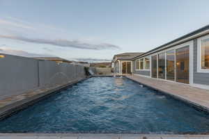 View of pool with a fenced backyard and a patio