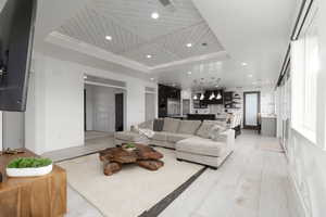 Living area featuring wooden ceiling, recessed lighting, and a raised ceiling