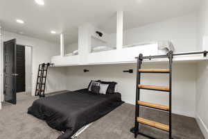 Bedroom with light colored carpet and recessed lighting