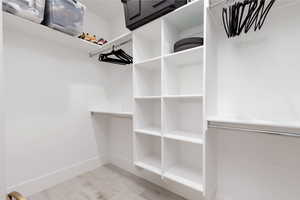 Spacious closet with light wood-style flooring