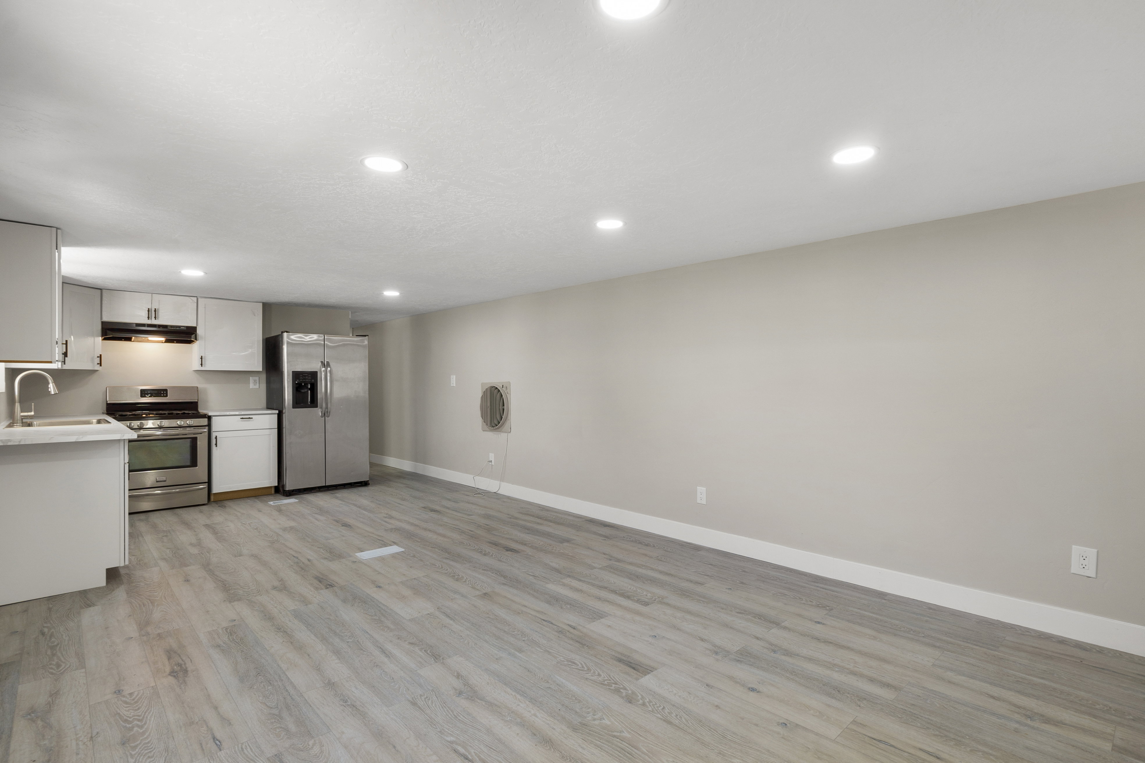 Kitchen featuring white cabinetry, stainless steel appliances, light countertops, light wood-style floors, and recessed lighting