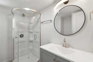 Bathroom featuring vanity and a shower stall