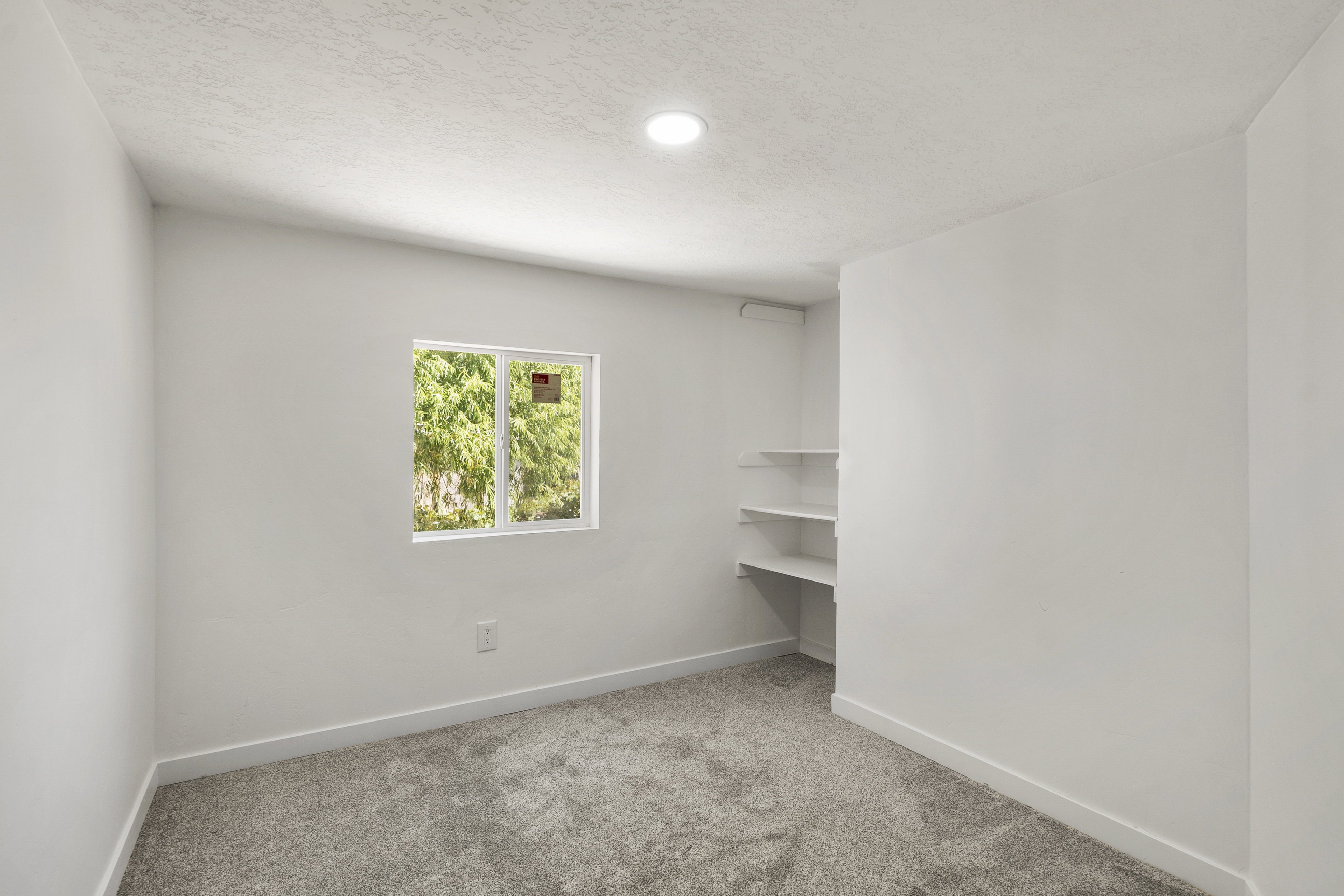 Unfurnished room with light carpet and a textured ceiling