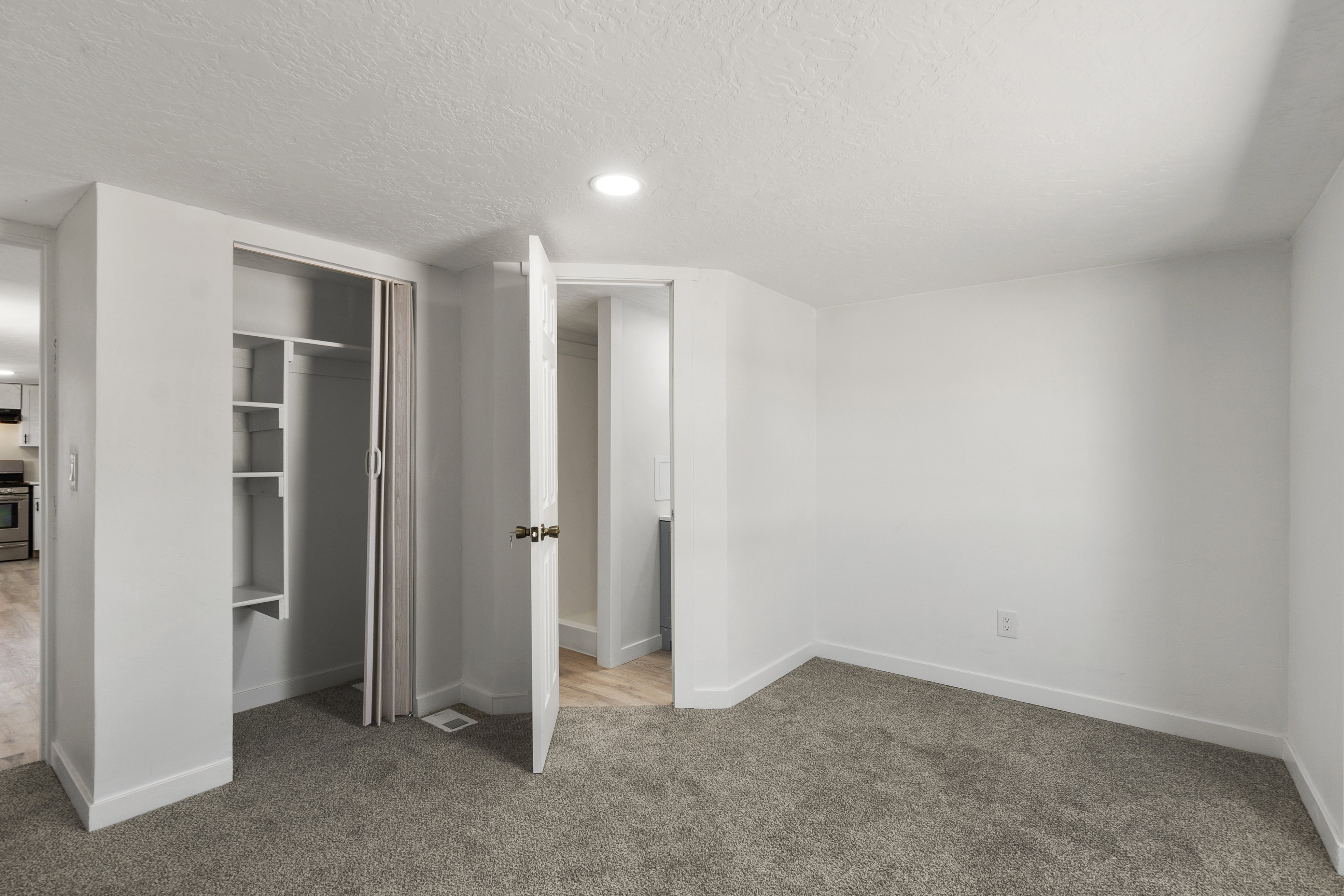 Unfurnished bedroom with light carpet, a textured ceiling, a closet, and recessed lighting