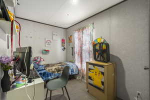 Carpeted bedroom with ornamental molding