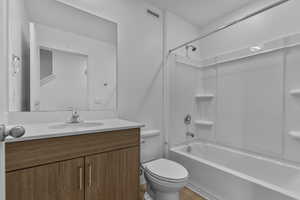 Bathroom featuring washtub / shower combination, vanity, and light wood-type flooring