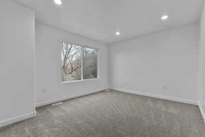 Unfurnished room with light colored carpet and recessed lighting