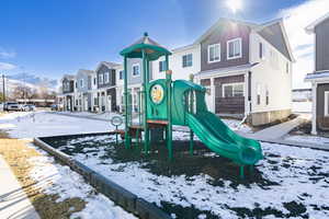 Snow covered playground featuring a residential view and a mountain view