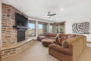 Family room featuring a stone gas fireplace, large view windows, a wet bar and walkout doors to the terrace