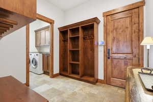 Mudroom with stone tile flooring, and cabinet space