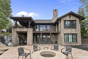 Back of house with a patio area, a covered deck and partially covered patio with water feature