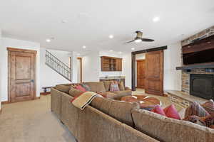 Family room featuring a stone gas fireplace, large view windows, a wet bar and walkout doors to the terrace