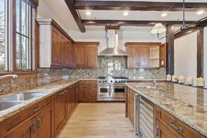Kitchen with wine cooler, double oven Viking range, light granite counters, and double dishwashers