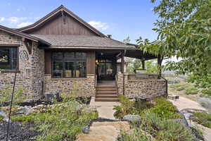 Entrance to deck with stone siding,  a garden pond, a deck, and a patio