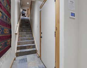 Stairs featuring stone finish flooring and recessed lighting