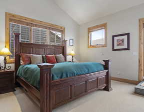 Bedroom with lofted ceiling and light carpet