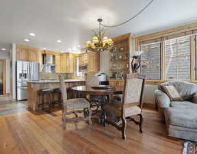 Dining area with light wood-type flooring, a chandelier, and recessed lighting