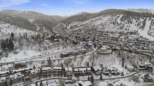 Snowy aerial view with a mountain view and a residential view