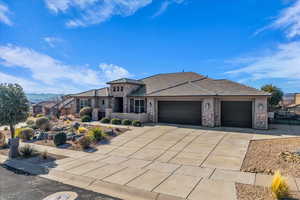 View of front of property with stone siding, an attached garage, stucco siding, and concrete driveway