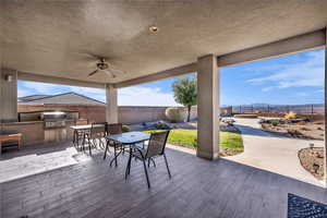 Fenced backyard with outdoor dining area, area for grilling, a ceiling fan, a patio, and a mountain view