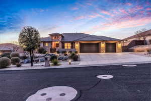 Prairie-style home featuring stone siding, a tile roof, stucco siding, concrete driveway, and a garage