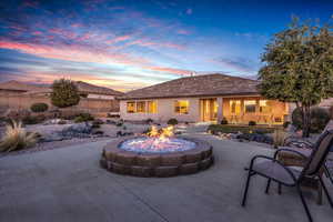 Back of property featuring an outdoor fire pit, a patio area, and stucco siding