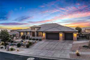 Prairie-style house featuring stone siding, an attached garage, concrete driveway, and a tiled roof
